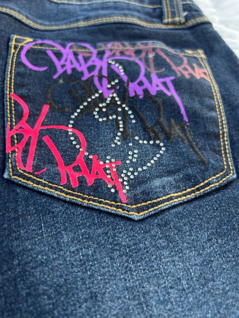 Baby Phat graffiti style dark wash Capri jeans.